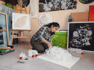 Artist Swapna Namboodiri working on a reclaimed plastic sculpture inspired by nature.